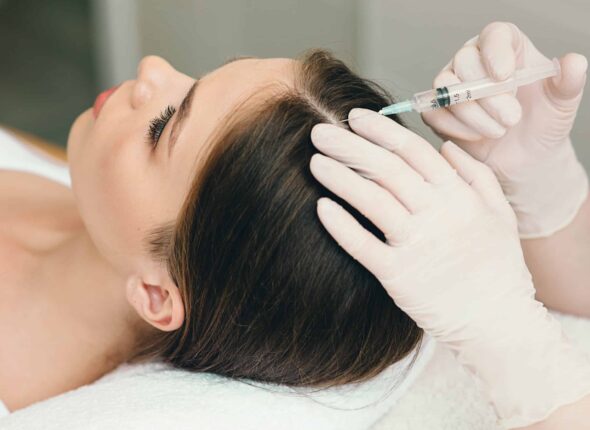 close up image of woman receiving a PRP injection into the part of her hair