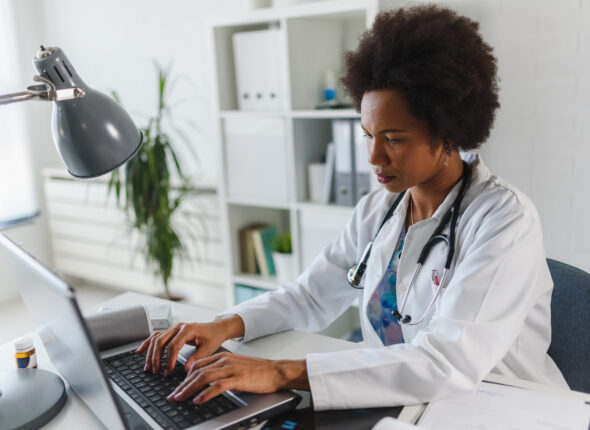 Serious concentrated African American doctor working in her office at clinic
